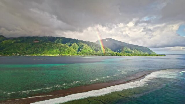 Aerial view of beautiful tropical island, rainbow, blue ocean and coral reefs. Paradise island of Tahiti in French Polynesia. 