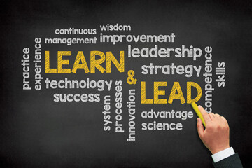 Learn and Lead concept with a male hand writing on chalkboard