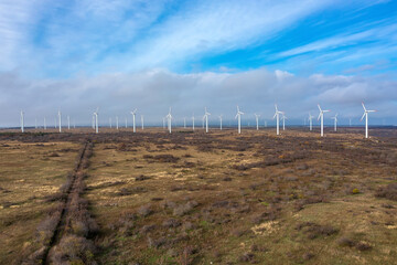 Obraz premium Aerial view to wind turbine farm. Horizontal view with cloudy sky