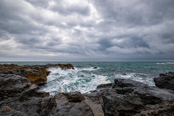 Fototapeta na wymiar Stunning seascape with scenic clouds over the sea with rocky shore