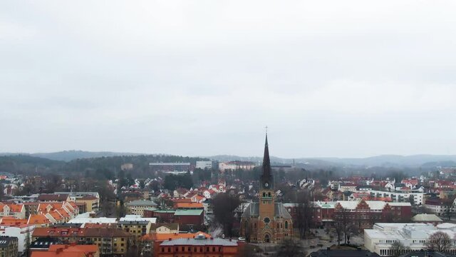 Majestic township skyline with church tower in Sweden, aerial tilt down shot