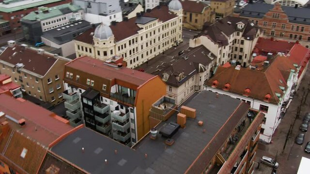 Downtown apartment buildings with colorful rooftops in close up aerial flying shot