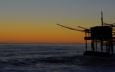 Fototapeta na wymiar Profilo del trabocco al tramonto sul mare