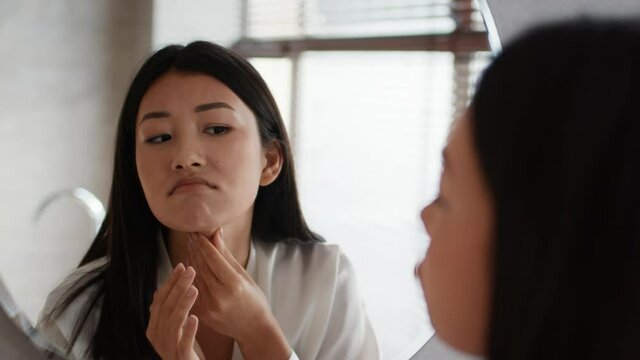 Unhappy Japanese Woman Touching Neck Skin Having Second Chin Indoor