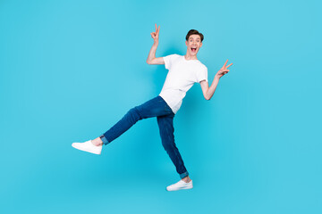 Fototapeta na wymiar Full body profile side photo of young crazy guy have fun show peace cool v-symbol isolated over blue color background