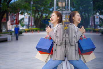 a beautiful girl standing in front of a boutique holding a shopping paper bag Portrait of a graceful young woman who enjoys shopping while shopping in the department store in the Sale season Copy spac