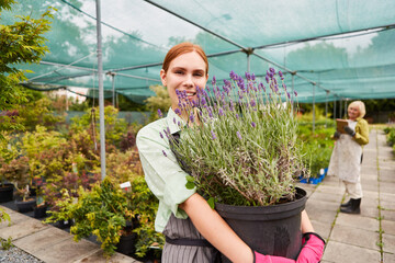 Junge Frau als Gärtner Azubi mit Lavendel Pflanzen