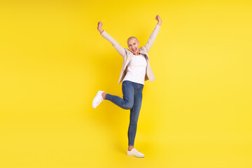 Fototapeta na wymiar Full size photo of cheerful senior lady have fun rejoice victory discount win lottery isolated over yellow color background