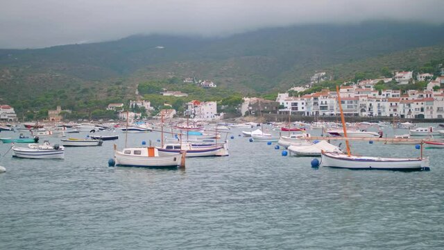 The white boats in the port of Cadaques, Costa Brava, Spain against the white sky
