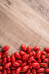Fresh cherry tomatoes over wooden table background.