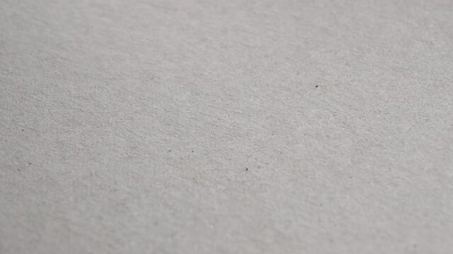 Grungy wrapping paper texture. Recycled rough sheet of delivery cardboard. Macro. Rotation. Mottled surface