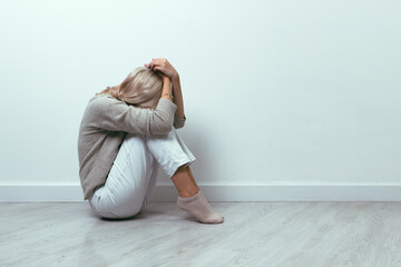 A young girl lies curled up on the floor. Depression concept.