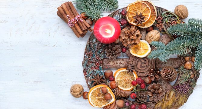 traditional Wiccan altar for Yule sabbath. Wheel of the year, candle, cinnamon sticks, nuts, cones, dry orange slices. Esoteric Ritual for Yule, Magical Winter Solstice. flat lay. copy space
