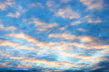 beautiful sunset sky with cirrus and cumulus clouds in late autumn or early winter with long rays of the setting sun