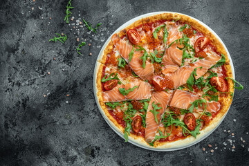 pizza with smoked salmon, red caviar, tomatoes and aragula ready to eat. banner, menu, recipe place for text, top view