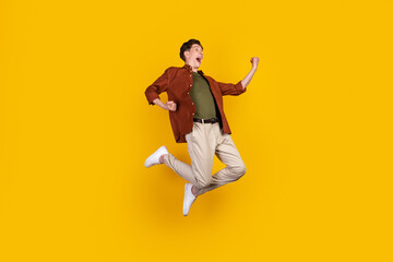 Fototapeta na wymiar Full length photo of young cheerful man rejoice victory awesome goal isolated over yellow color background