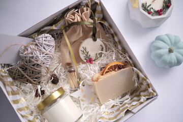 Preparing care package, seasonal gift box with soap and candle. Personalized eco friendly basket for family and friends for thanksgiving, christmas, mothers and fathers day holidays.