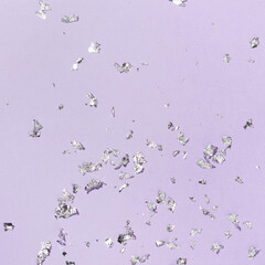Party creative layout silver foil leaf flakes decoration on pastel purple background. 80s or 90s...