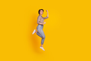 Fototapeta na wymiar Full body profile side photo of young cheerful lady have fun jump celebrate victory isolated over yellow color background