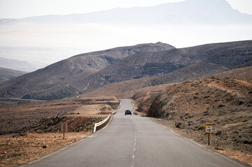 car on asphalt road in mountainous terrain