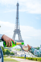 Bottle and glass of champagne on the background of the Eiffel Tower