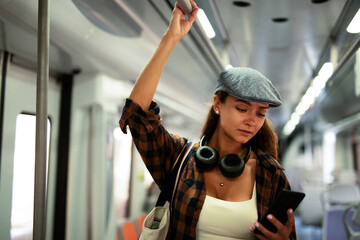 Young woman travelling by train. Beautiful girl typing a message while travel