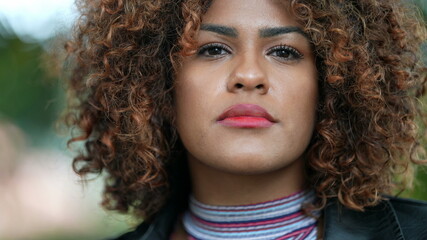 Brazilian black woman portrait close-up face looking at camera with curly hair