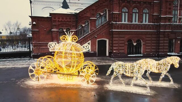 A carriage with horses made of luminous garlands on the city square. Fabulous Christmas shining illumination, New Year's decoration. Merry christmas celebration concept. 4K UHD.