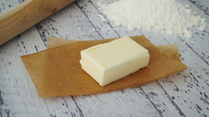 ブラウンの紙にのせられたバターと小麦粉,、めん棒