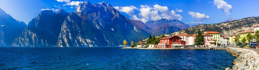 Beautiful lake  Lago di Grada. Panoramic view of Torbole village with colorful houses amd high...