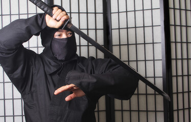 Asian Man Wearing Ninja Costume and holding Ninja Weapons © LMPark Photos