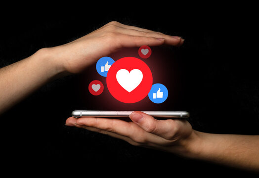 Social media concept. Hands with smartphone and like notification icon. Social networking, black background photo