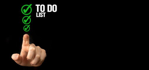 Fototapeta premium To do list with checklist boxes. Hand marking check list on a black background, banner photo