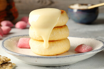 Appetizing syrniki (cottage cheese pancakes), sprinkled with sweet, condensed milk. Delicious and nutritious breakfast.