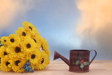 Yellow Flowers and Metal Water Can with Blue Sky Background