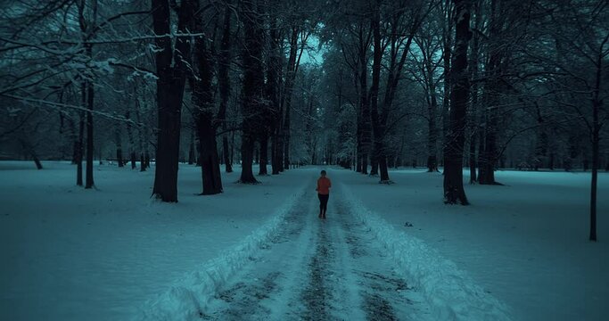 Running woman, girl runner on snow in park in winter sunny day. Female in pink sportswear jacket fitness training outdoors. Run, Sport concept, leisure and freedom.