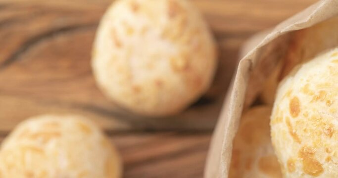 Typical brazilian cheese buns in a paper bag over wooden table