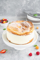 Traditional Polish cake Karpatka on a gray concrete background. Cake of choux pastry dough and custard cream with fresh berries and powdered sugar on top. Carpathian cake. Copy space.