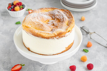 Traditional Polish cake Karpatka on a gray concrete background. Cake of choux pastry dough and custard cream with fresh berries and powdered sugar on top. Carpathian cake. Copy space.