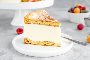 Traditional Polish cake Karpatka on a gray concrete background. Cake of choux pastry dough and custard cream with fresh berries and powdered sugar on top. Carpathian cake. Copy space.