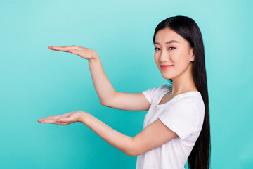 Photo of positive lady hands hold measure empty space wear white t-shirt isolated turquoise color background