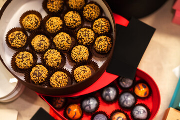 A box of truffle chocolates with nuts on the festive table.
