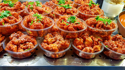 Local speciality on Wangfujing street in Beijing, China. There are lots of small plastic bowls filled with chicken meat and decorated with fresh parsley waiting to be bought and eaten. Food street.