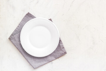 Empty plate on napkin - table setting for dinner. Overhead view