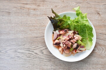 Thai spicy squid salad and fresh vegetable on plate