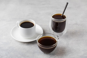 Different cups with instant coffee on grey stone kitchen table in light studio