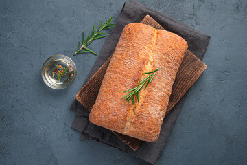 Ciabatta with olive oil and rosemary on a graphite background.