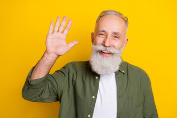 Photo portrait of grandfather smiling happy waving hand greeting isolated bright yellow color background © deagreez