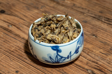 Dried razor clams in containers on wood grain countertops