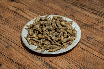 Dried razor clams in containers on wood grain countertops